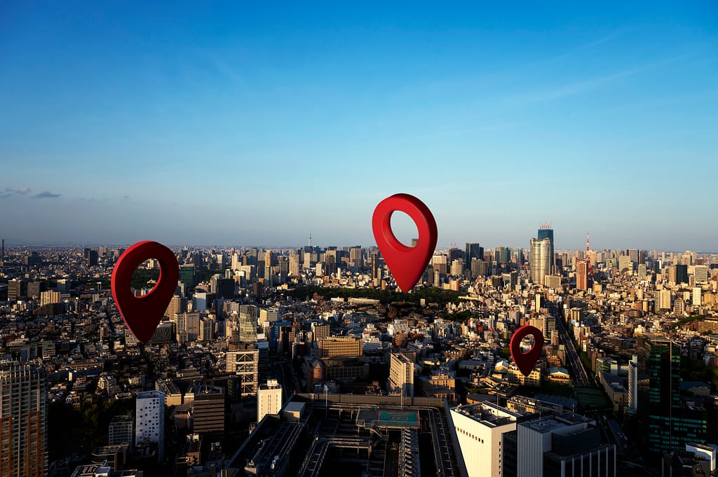 Red location pin icons placed against a city background, symbolizing geographic distribution or mapping.
