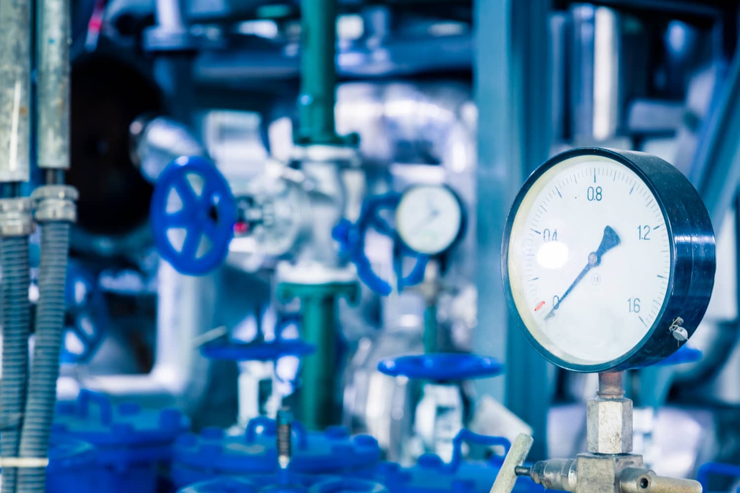 Industrial steel pipelines using different liquid flow meter types inside a processing plant, illustrating the infrastructure used for fluid transportation and flow measurement.