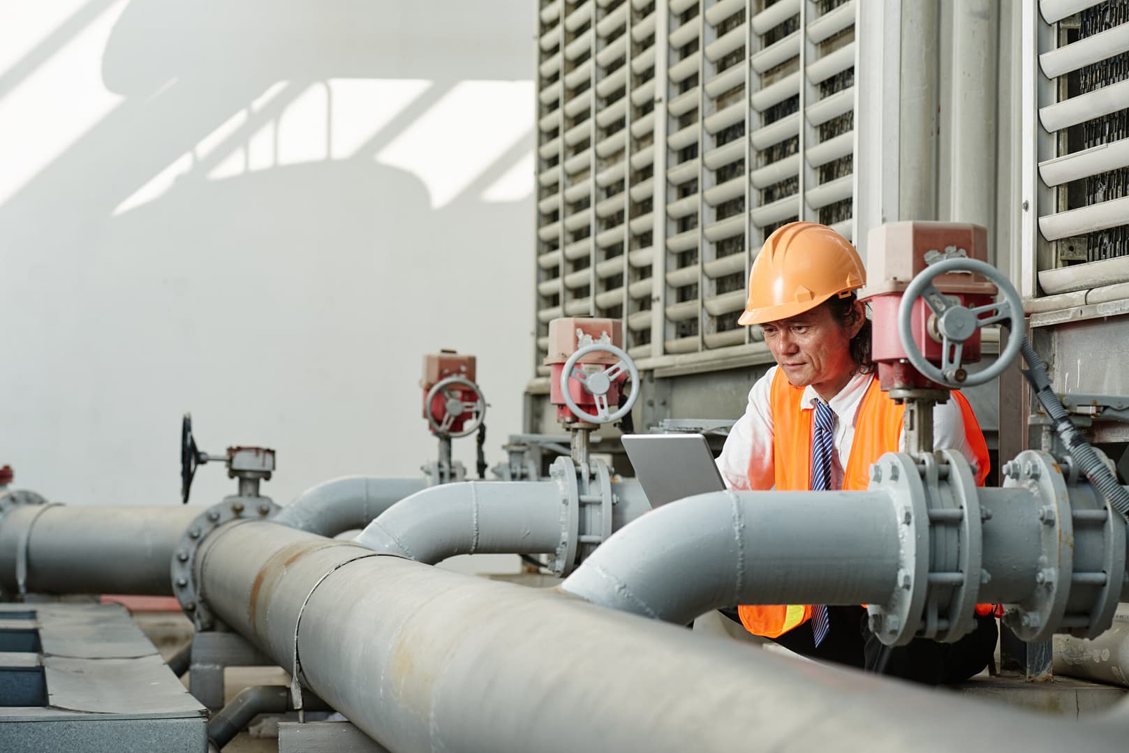 A person reading an instruction manual with a focus on technical details related to a flow meter device.